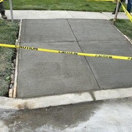 Concrete Sidewalk & Curbing — New concrete sidewalk installation with safety markings.