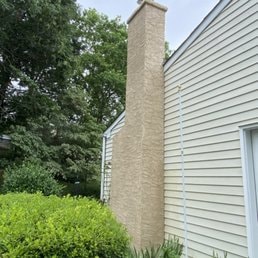Brick Chimney & Siding — Brick chimney beside house siding.