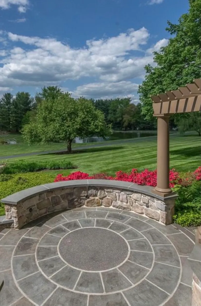 Circular Stone Patio — Flagstone circular patio with stone bench wall and pergola.